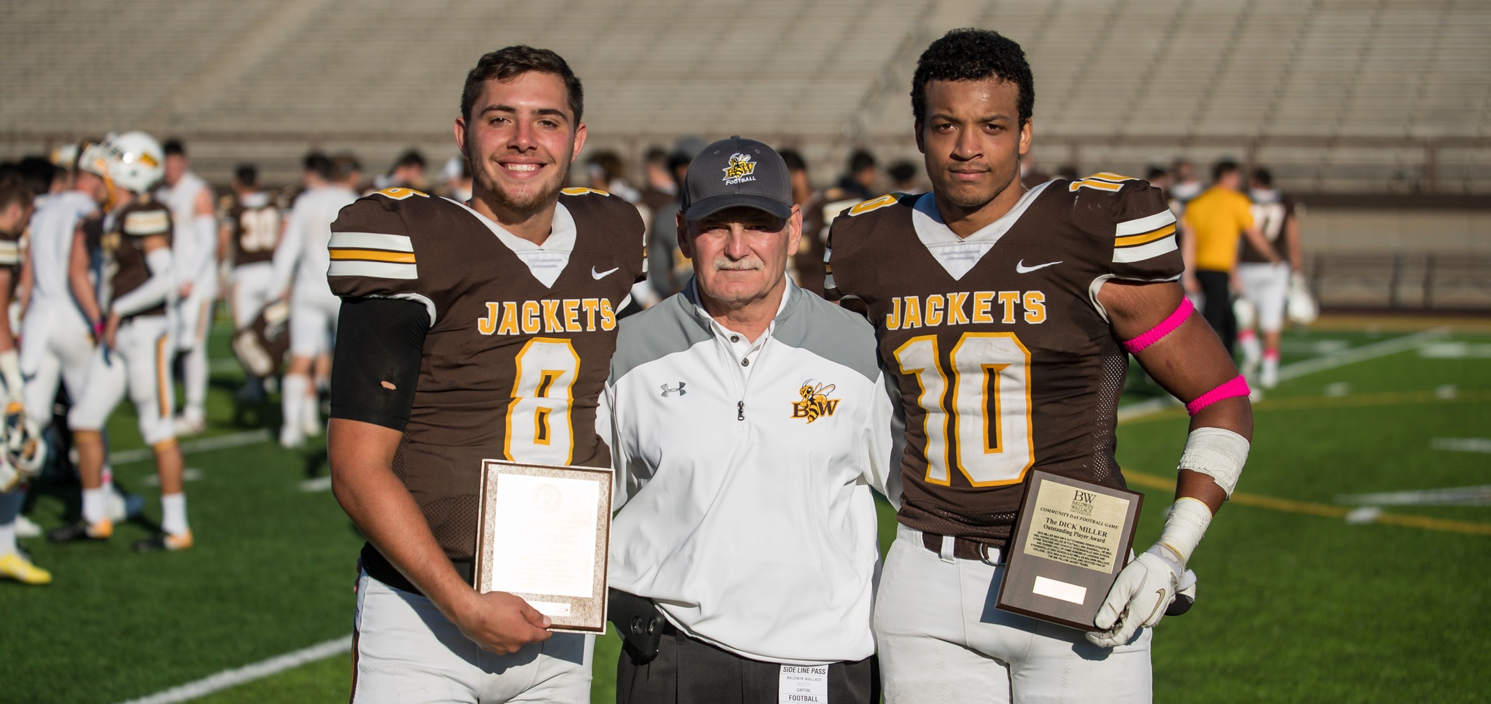 Freshman quarterback Keagan Armitage, Director of Athletics Kris Diaz and senior defensive lineman Sekou Imani after the Community Day and Homecoming win over Capital University (Photo courtesy of Jesse Kucewicz)